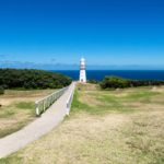 Cape Otway Lighthouse in grassland with bench and overlook at the ocean at the Great Ocean Road, Victoria, Australia