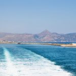 Boat trails in the ocean with view on the port of Heraklion and mountains in Crete, Greece, Europe