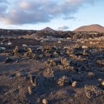 El Restinga, El Hierro, Canary Islands - Sunshined lava rocks spreaded in black sand with moon-like landscape during sunset, Spain