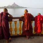 Hpa-an Myanmar Three monks standing at the pagoda along the river with mountain enjoying the sunset