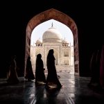 Women in traditional saris passing arch in Taj Mahal in Agra, Uttar Pradesh, India